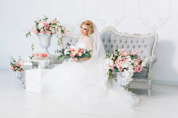 Virágok körül a gyönyörű szőke menyasszony — Stock Fotó