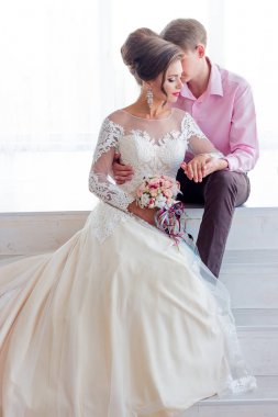 Damat gelini arkadan sarılarak