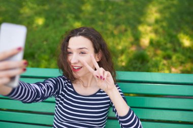 Fotoğraf makinesi ve kendini alarak fotoğraf için poz trendy genç kadın