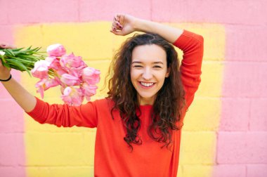 renkli sarı ve pembe arka plan üzerinde kırmızı kazaklı güzel kız.