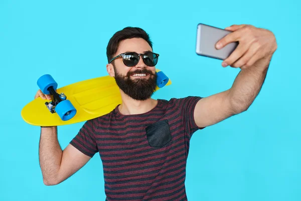 Jeune homme avec barbe faire un selfie — Photo