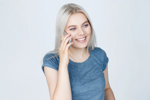 Mujer linda joven hablando por teléfono sobre fondo gris —  Fotos de Stock