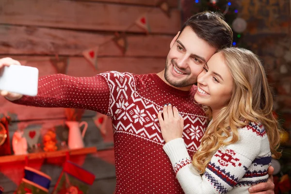 Casal feliz em camisolas quentes tirar foto selfie no Natal — Fotografia de Stock