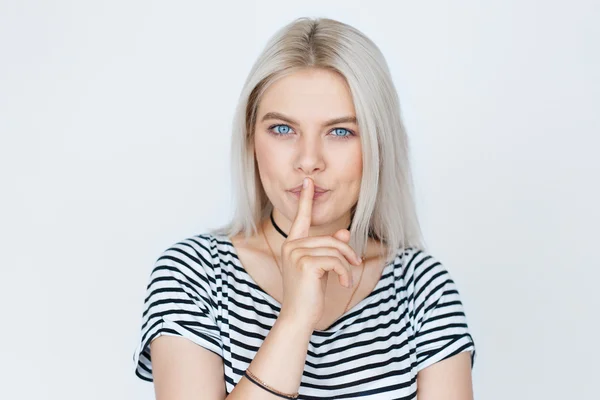 Retrato de una hermosa mujer rubia con el dedo en los labios — Foto de Stock