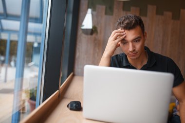 Kafe içinde pencerede çalışan adam