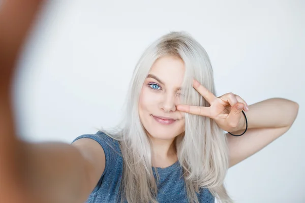 Hymyilevä nuori tyttö tekee selfie kuva — kuvapankkivalokuva