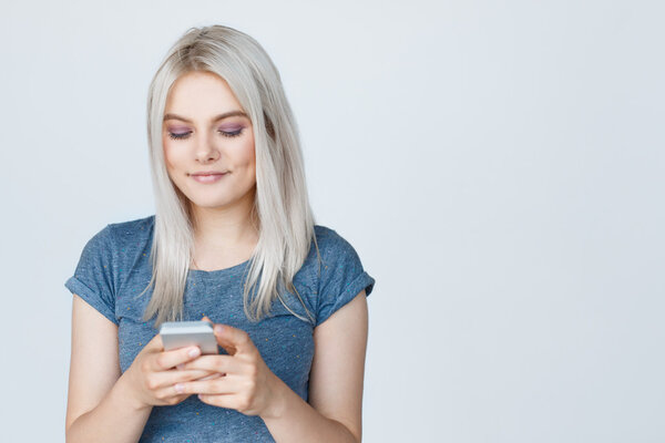 блондинка-подросток пишет смс на смартфоне
