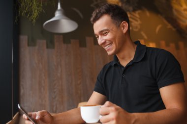 mutlu genç adam akıllı telefon tutarak ve tipik bir haber