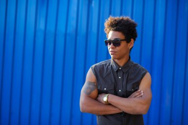 Afro Amerikan kıvırcık genç adam mavi duvar