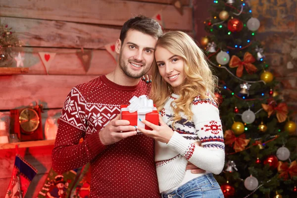 Happy couple holding Christmas present — Stock Photo, Image