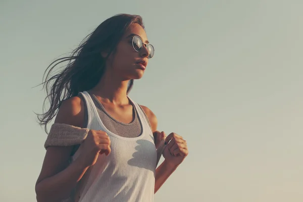 Traveling young woman with backpack wearing sunglasses — Stockfoto