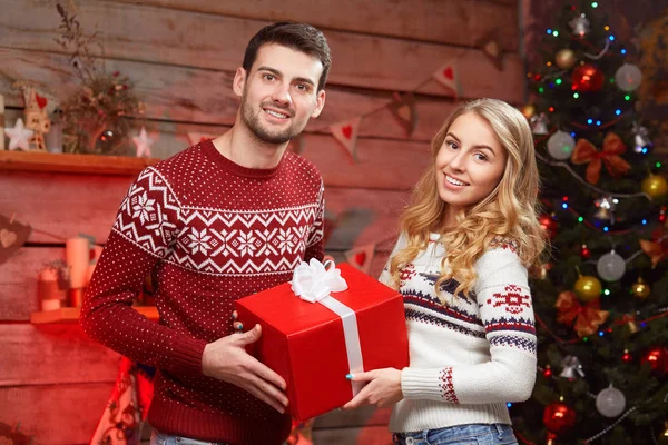 Glückliche junge Leute beschenken den Weihnachtsbaum — Stockfoto