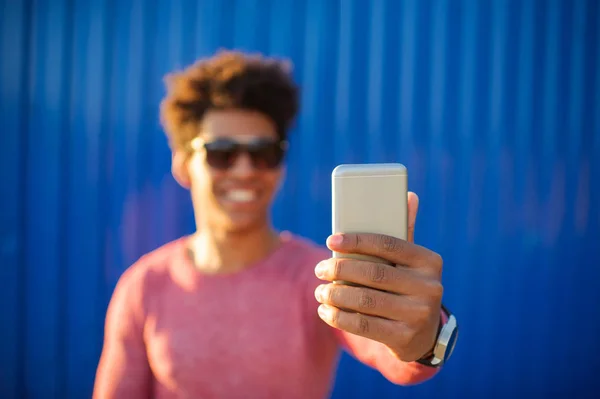 Genç adam cep telefonu ile kendi kendine portre çekici — Stok fotoğraf