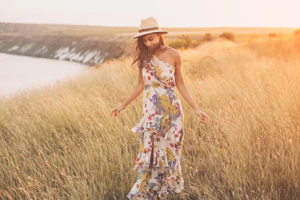 ผู้หญิงในชุดฤดูร้อน เดินในทุ่งหญ้า — ภาพถ่ายสต็อก