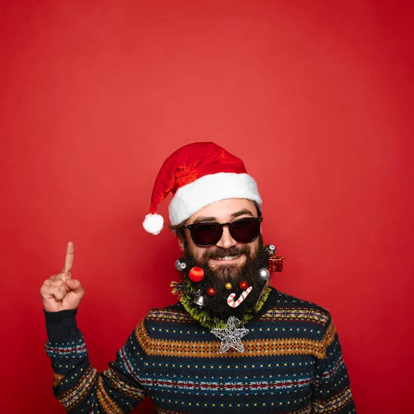 handsome new year man with decorated beard pointing up