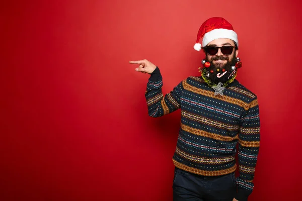 Homem hipster barbudo em Papai Noel gesticulando à esquerda — Fotografia de Stock