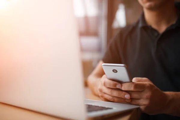 Young smart man working with laptop computer and smartphone — Stock Photo, Image