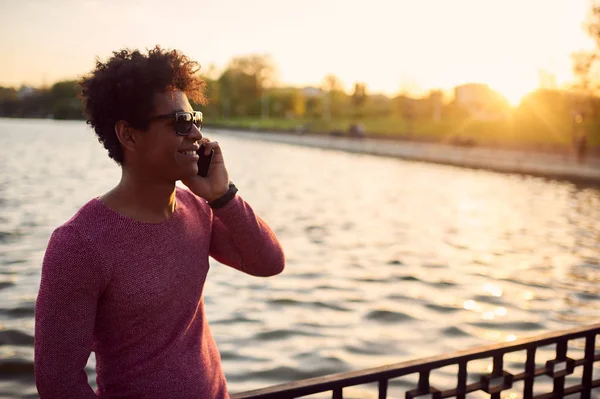 Silueta del hombre de pie al aire libre en el lago con teléfono — Foto de Stock