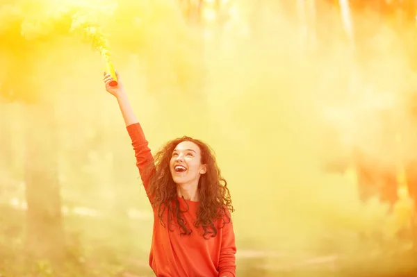 Chica feliz con colorida bomba de humo — Foto de Stock