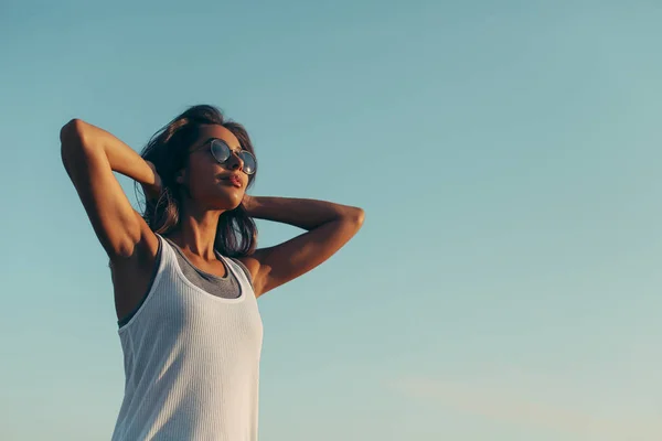 Jovem mulher sobre o céu azul — Fotografia de Stock