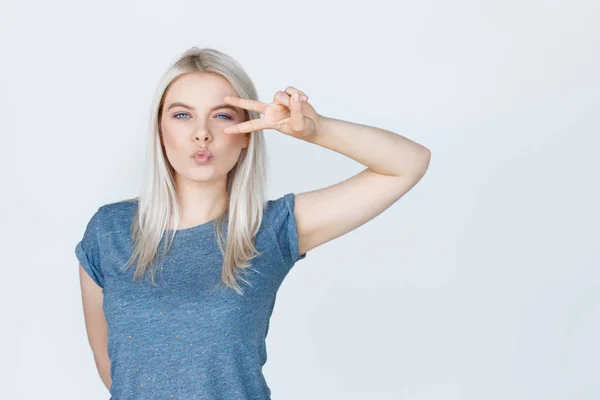 Dospívající dívka s plavými vlasy, zobrazující znamení míru — Stock fotografie