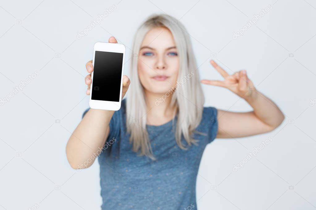 Young woman showing blank smartphone screen