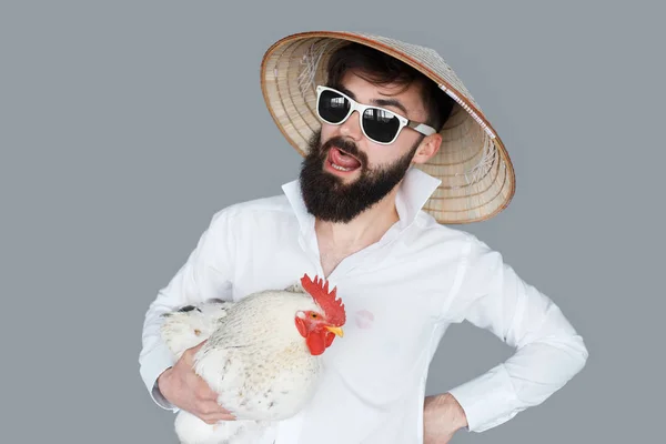 Бородатий чоловік у білій сорочці тримає курку — стокове фото