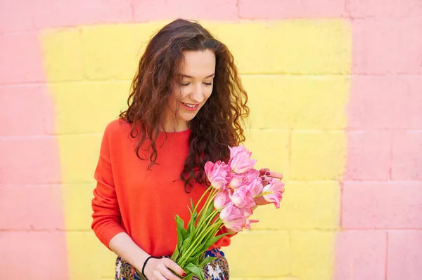 Fille bouclée en vêtements à la mode sur fond jaune coloré . — Photo