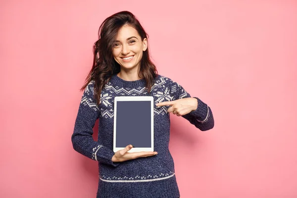 smiling woman pointing to tablet screen