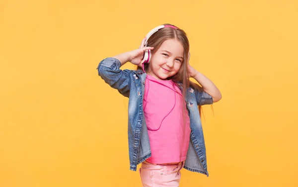 Menina segurando os fones de ouvido e sorrindo — Fotografia de Stock