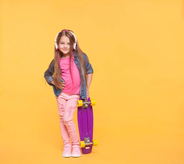 Menina na moda criança ouvindo música em fones de ouvido — Fotografia de Stock
