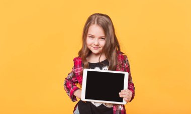 küçük kız boş siyah tablet pc sarı arka plan üzerinde gösterilen