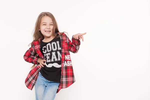 Menina da escola da criança feliz apontando com o dedo no branco — Fotografia de Stock