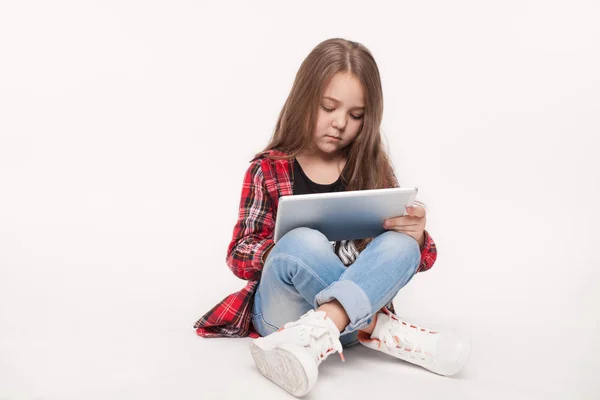 Pequeña estudiante chica con tableta pc haciendo tarea — Foto de Stock