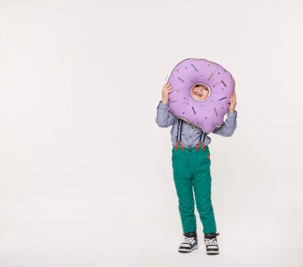 Küçük çocuk büyük bir yastık çörek şeklinde holding — Stok fotoğraf