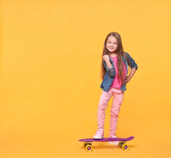 Kleines Mädchen in bunten Kleidern zeigt Erfolgsgeste — Stockfoto