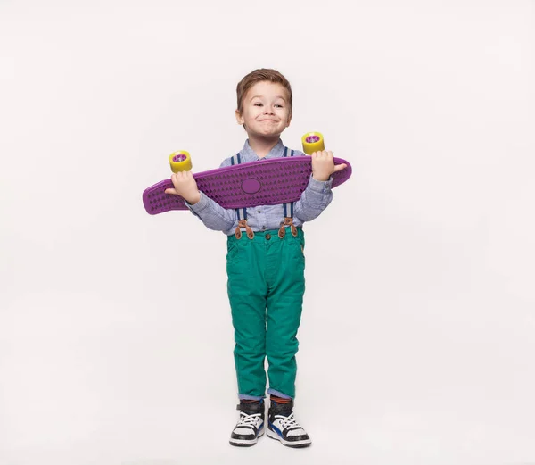 Stylish kid boy holding his birthday gift skateboard — Stock Photo, Image