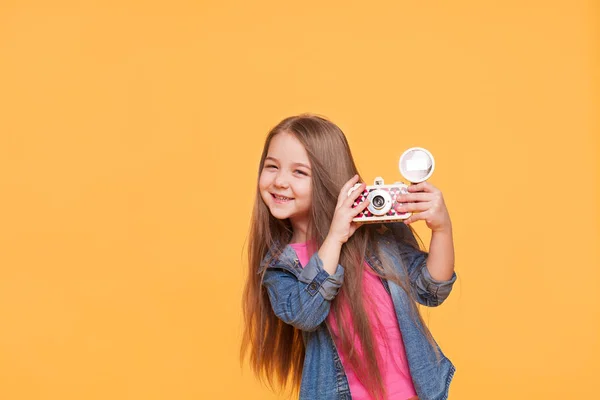 Kis lány fotós mosolyogva és a gazdaság egy retro fényképezőgép — Stock Fotó