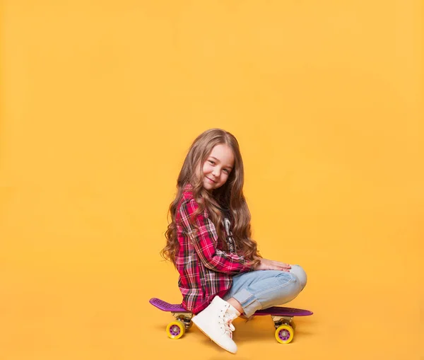 Šťastné dítě dívka sedící na skateboard — Stock fotografie