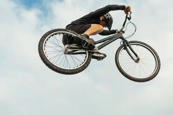 Mann springt auf Fahrrad — Stockfoto