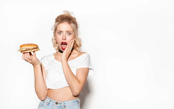 햄버거를 들고 놀된 젊은 여자 — 스톡 사진
