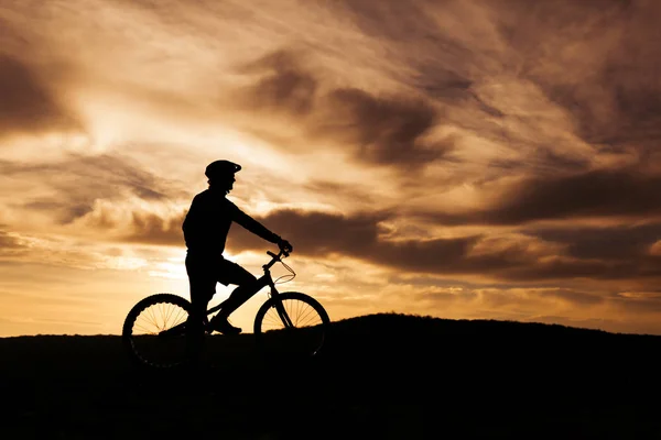 Silhouette of a person on a bike — Stock Photo, Image