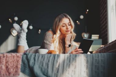 Kadın yatakta tablet tarama