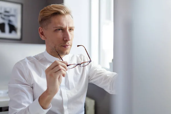Hombre sosteniendo gafas y mirando a la pantalla —  Fotos de Stock