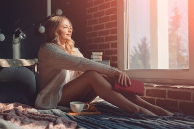 kitap ile oturan kadın