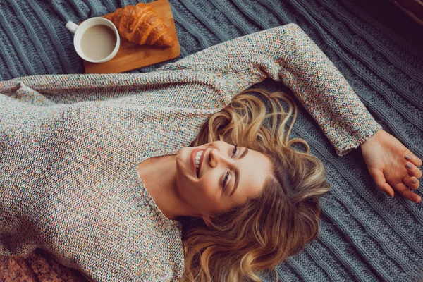 Mujer sonriente acostada en la cama — Foto de Stock