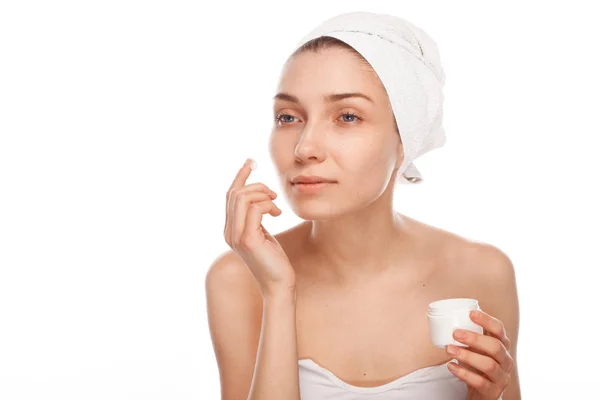 Young female applying cream on face — Stock Photo, Image