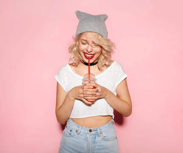 Smiling young woman drinking soda