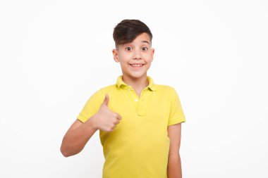 Gülümseyen çocuk baş parmağını gösteriyor.