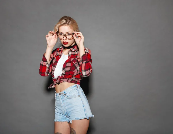 Pretty young blond adjusting glasses — Stock Photo, Image